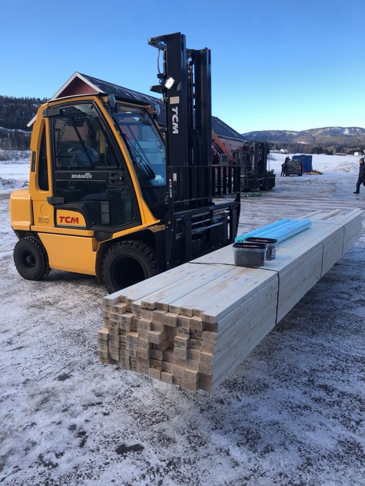 Truck som laster en pakke med konstruksjonsvirke